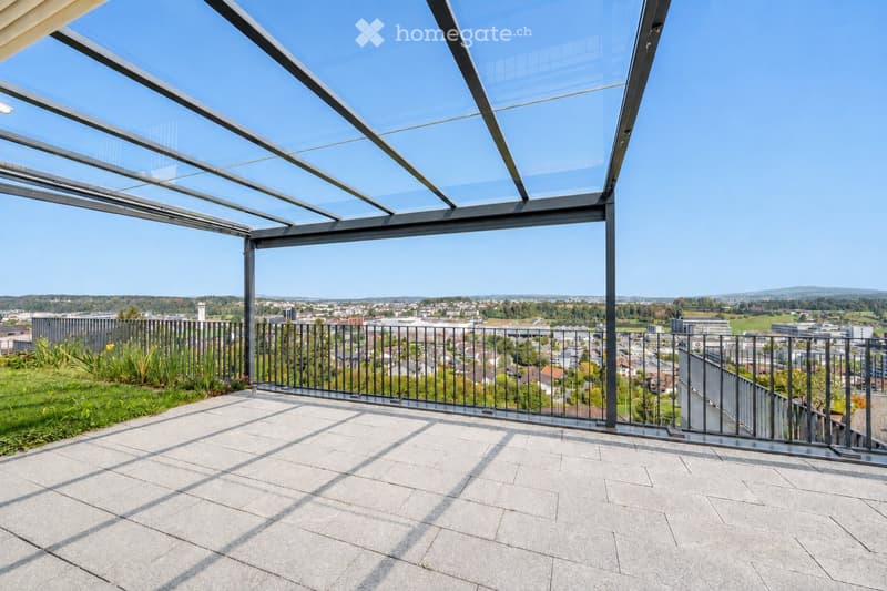 Modern rooftop terrace with a glass roof structure, metal railing, and expansive cityscape view.