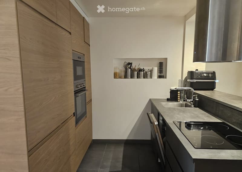 Modern kitchen with wooden cabinets, stainless steel appliances, and a sleek countertop.