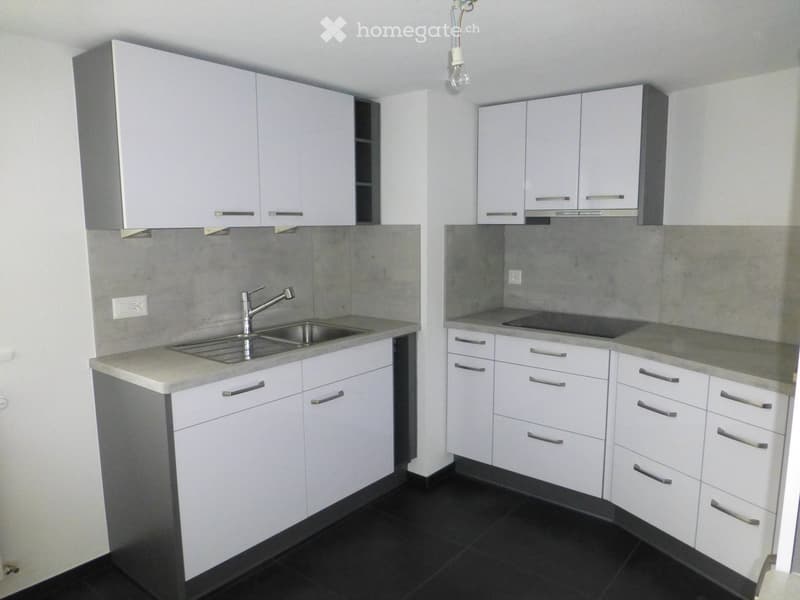 Modern kitchen with white cabinets, stainless steel sink, and countertop. Features include a built-in stove and ample storage space.