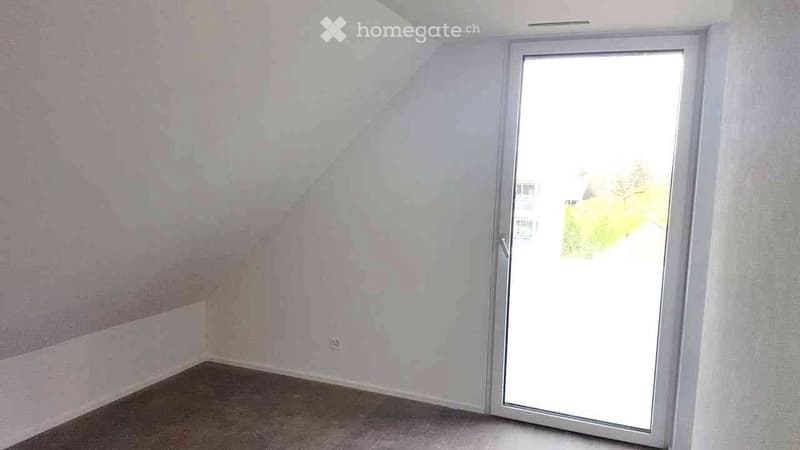 Empty room with sliding glass door, electrical outlet on wall, carpeting