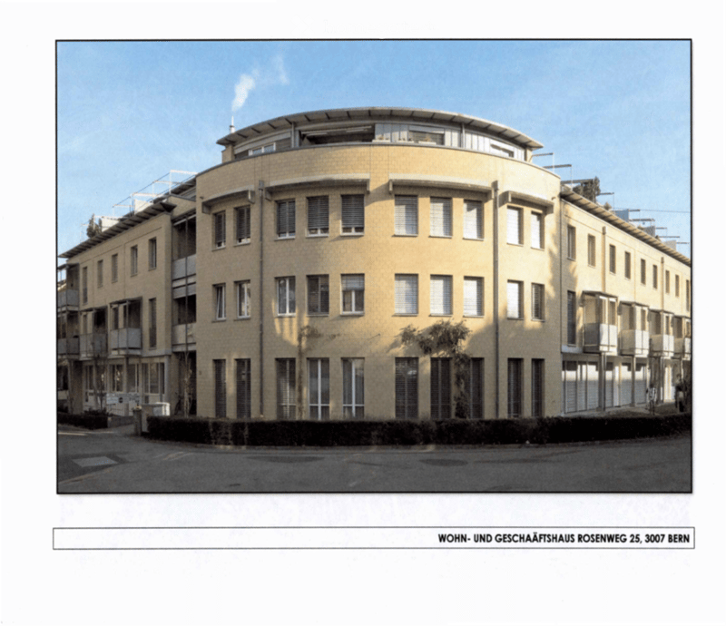 Modern multi-story residential and commercial building with a curved facade, numerous windows, and balconies.