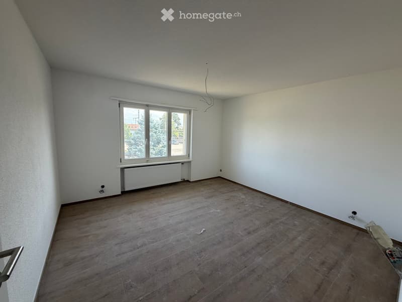 Empty room with wooden flooring, white walls, and a window with a radiator below it. No furniture or equipment is present.