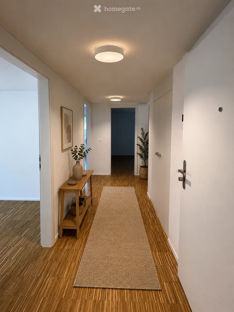 Modern hallway with wooden flooring, white walls, recessed lighting, a small wooden table with a vase and plant, a picture frame on the wall, and a beige runner rug.