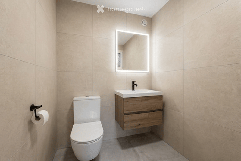 Modern bathroom with beige tiles, a toilet, a wooden sink cabinet, and a backlit mirror above the sink.