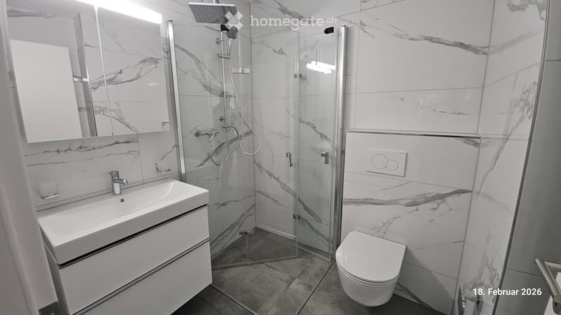 white walls and floor tiles, large mirror, sink, shower area, toilet