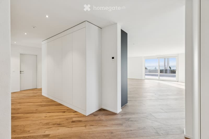 Minimalist room with white walls, wooden floor, large window, and door