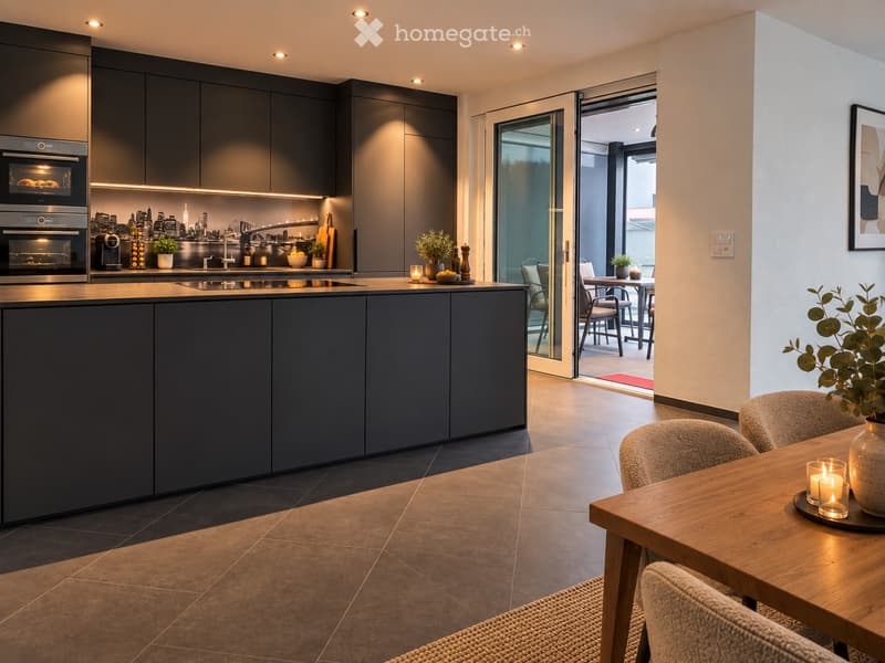 Modern kitchen with dark grey cabinets, stainless steel oven, coffee machine, and a wooden dining table with chairs. A sliding glass door opens to a balcony with outdoor furniture.