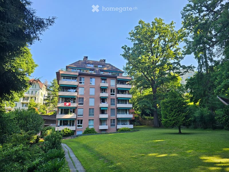 A modern pink apartment building with multiple balconies and windows