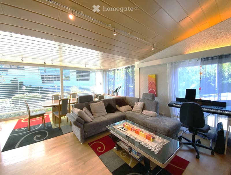 Empty room with wooden flooring, large windows, and recessed lighting. No furniture or equipment present.