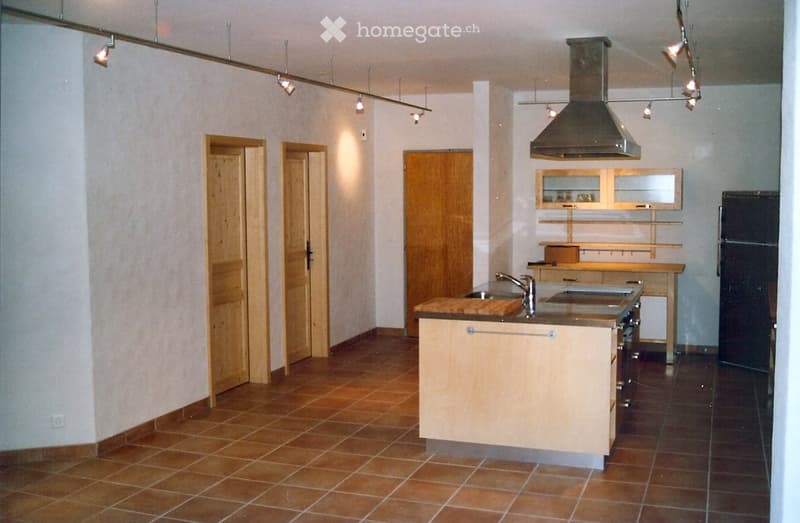 kitchen with island, wooden cabinets, tiled floor, stainless steel appliances, wooden doors, track lighting