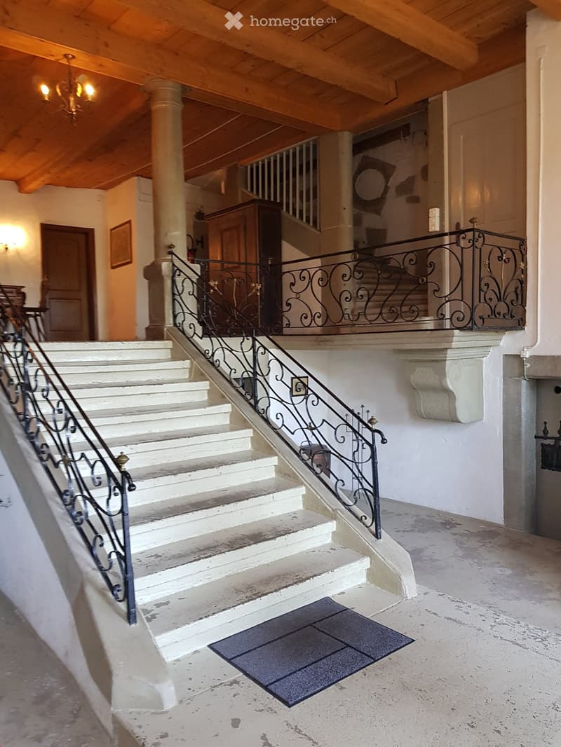 white marble stairs, wooden ceiling, black railings, wooden door, picture frame