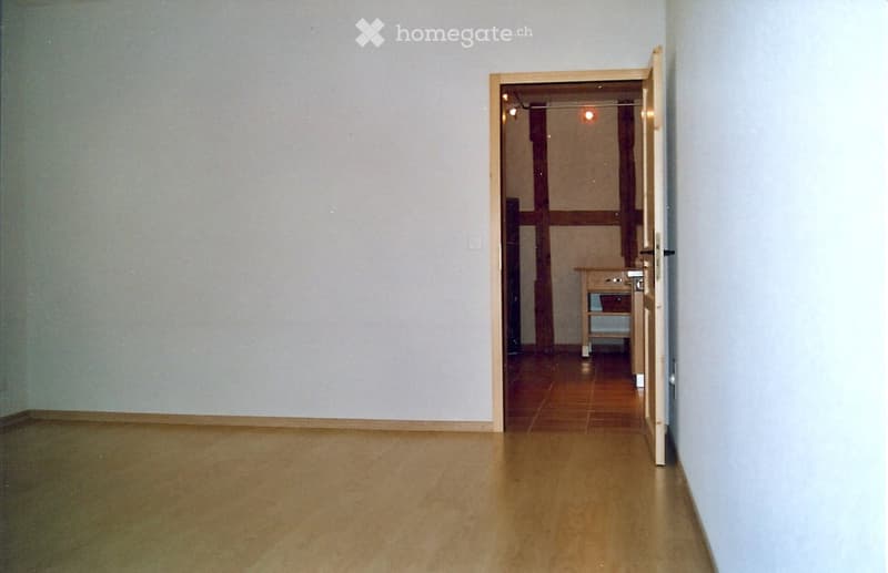 empty room, wooden floor, white walls, open door, small table