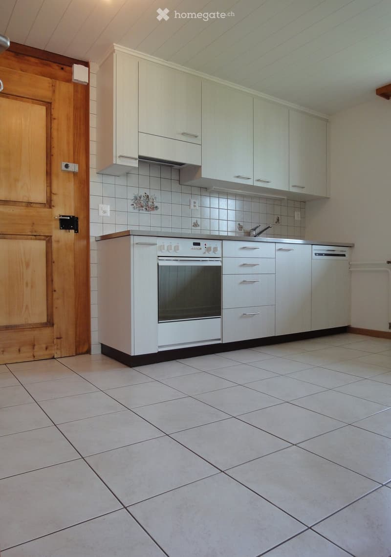 Modern kitchen with white cabinets, an oven, a dishwasher, and tiled walls and floor.