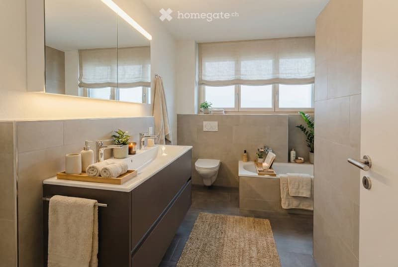 modern bathroom with bathtub, sink, toilet, towels, soap, shampoo, mirror, and potted plants