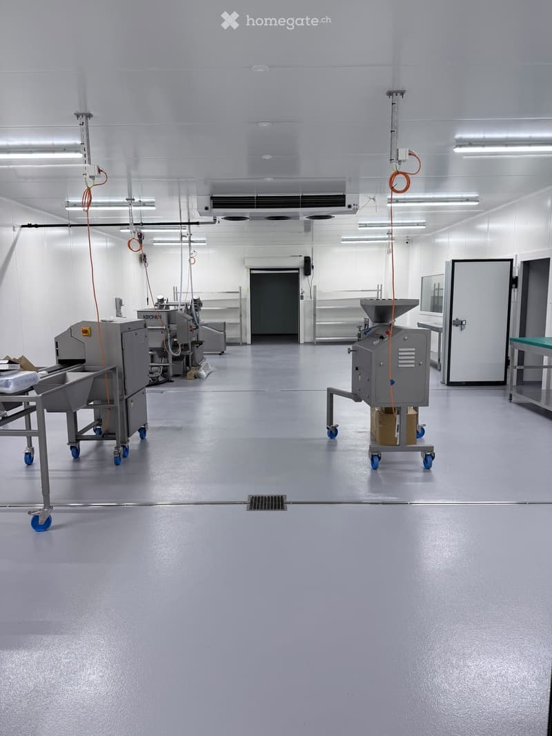 Clean, industrial-style room with stainless steel equipment, large doors, and a polished floor.