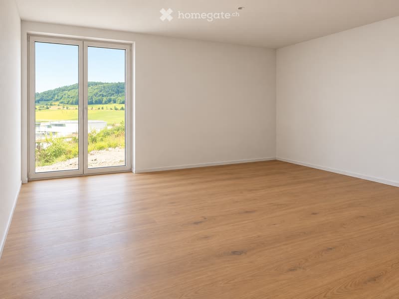 Empty room with light wooden flooring and large sliding glass doors leading to a scenic outdoor view.