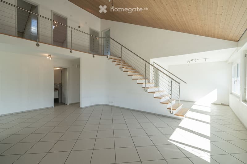 Open, modern hallway with a staircase leading to an upper level, white tiled floor, white walls, wooden ceiling, and a metal railing.