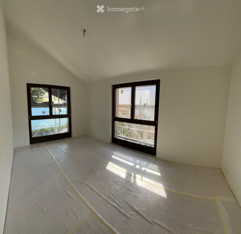 Unfurnished Room. Empty room with light-colored walls and a concrete floor, featuring two large windows that offer a view of a pool and outdoor area.