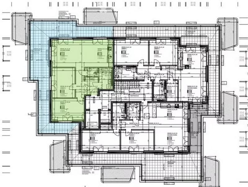 Floor plan of a large residential building with multiple rooms including living areas, bedrooms, bathrooms, and a central courtyard.