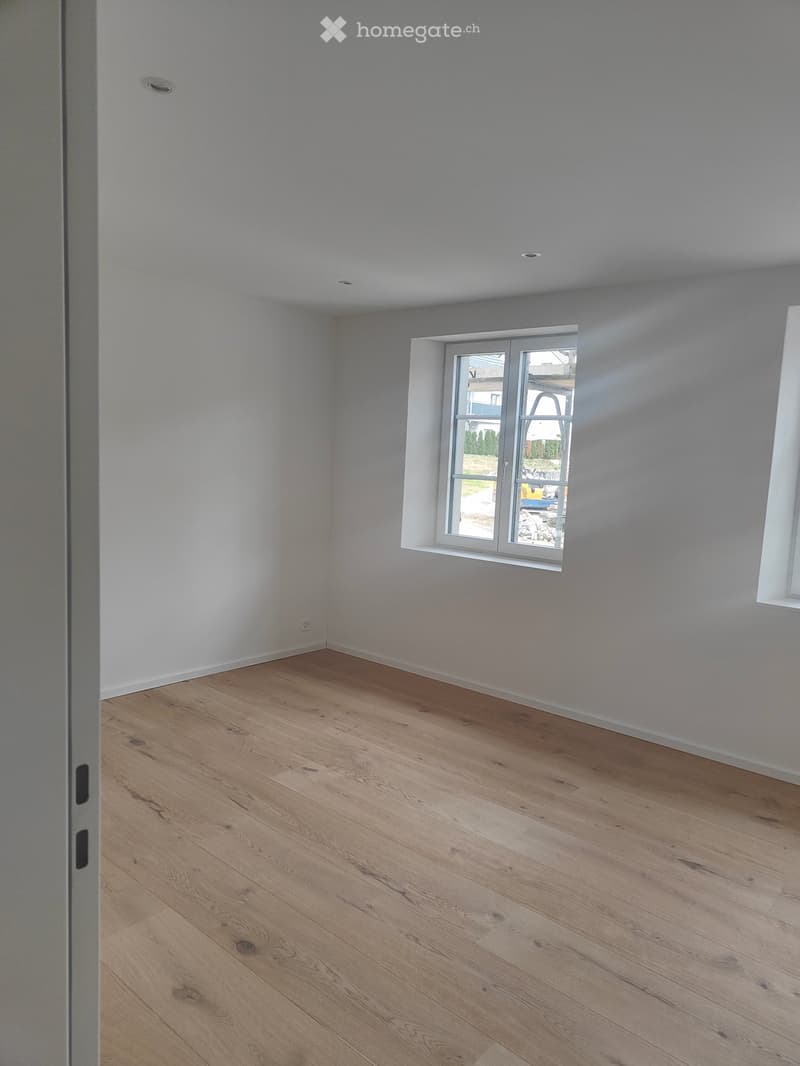 empty room, white walls, wooden floor, two windows, no furniture