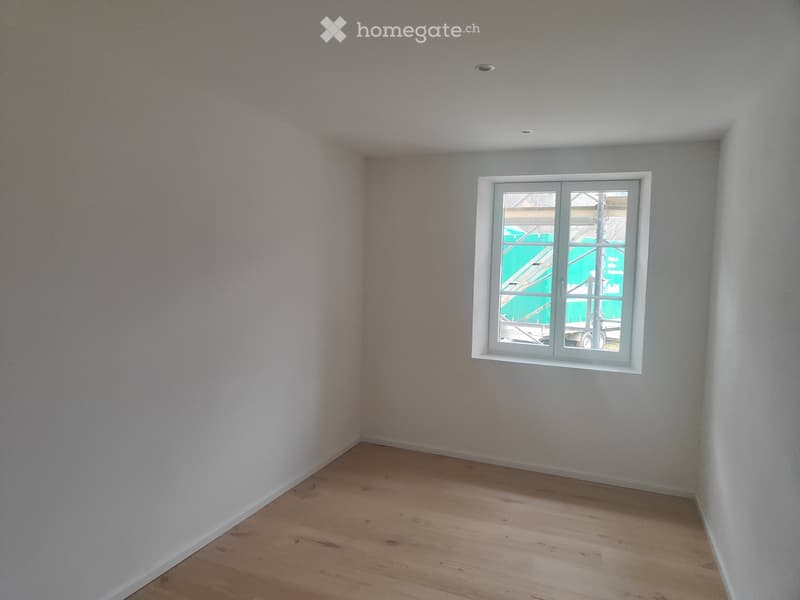 Empty room with wooden floor and a single window
