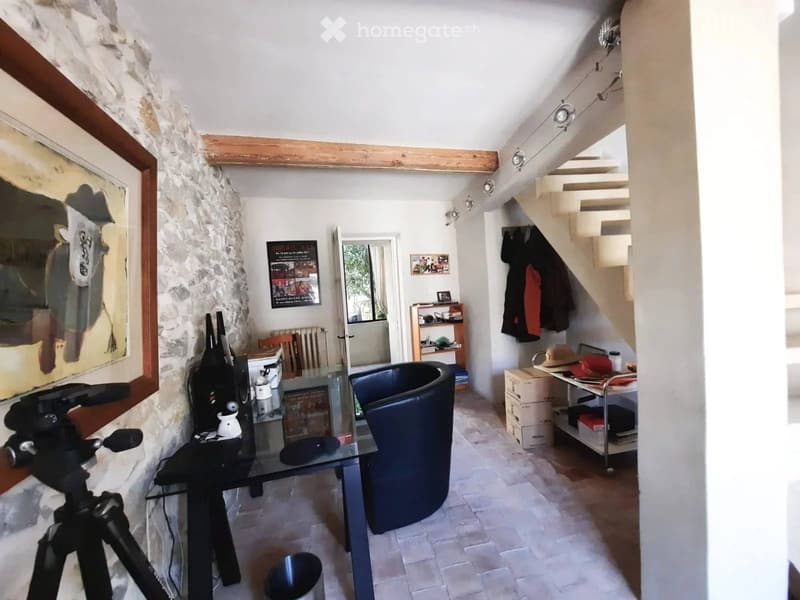 stone wall, glass table, chair, staircase, picture, shelves, radiator, items