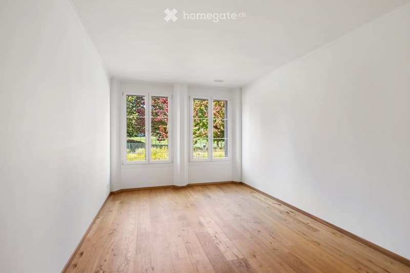 Completely empty room with bare white walls and wooden floor. No furniture or equipment.