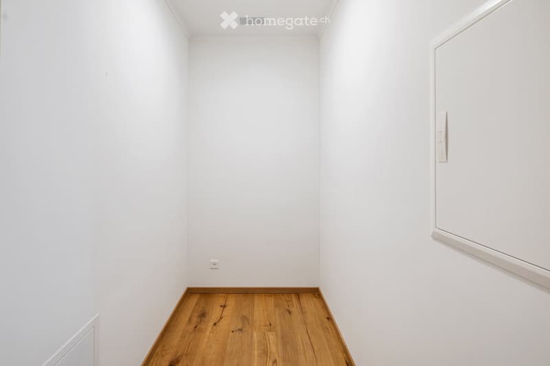 Completely empty room with white walls and wooden floor. No furniture or equipment.