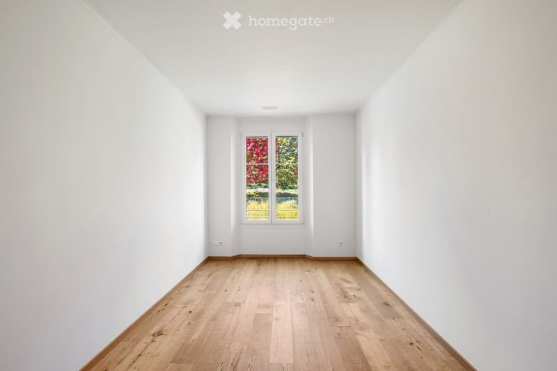 Completely empty room with bare white walls and light wooden flooring. No furniture or equipment.