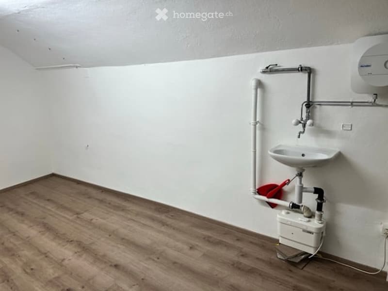 empty room, wooden floor, white wall, white sink, water tank, pipe