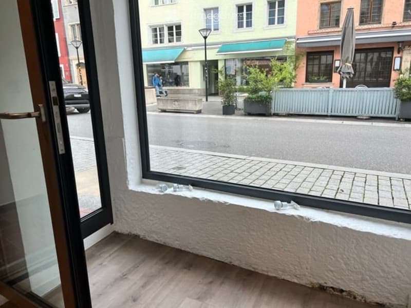open window with city view, wooden floor, white wall