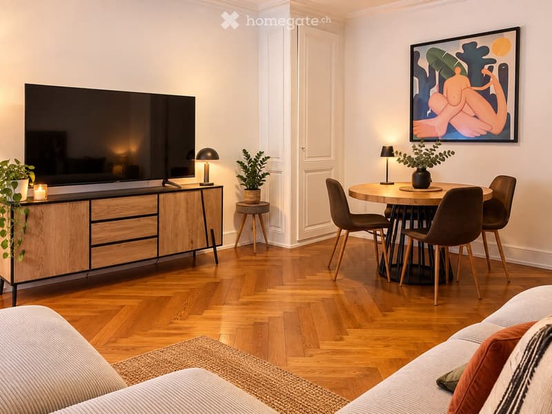 Modern living room with a large flat-screen TV on a wooden cabinet, a round dining table with four chairs, a sofa with pillows, and decorative plants and lamps.