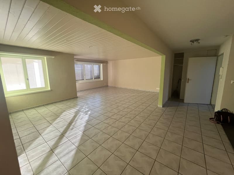Empty room with tiled floor, large windows, and a closet area. No furniture or equipment visible.