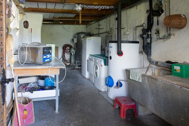 Utility room with a washing machine, refrigerator, microwave, sink, and various tools and equipment.