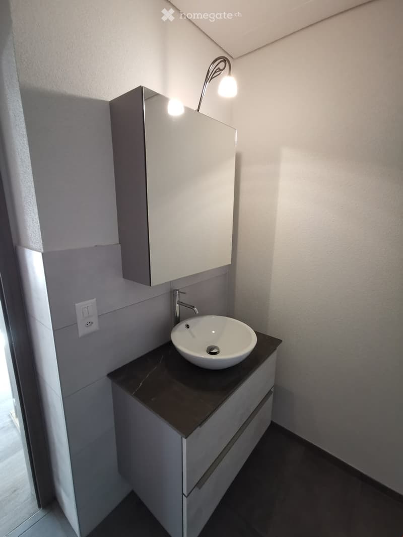 modern bathroom with white sink, mirror, faucet, countertop, cabinet, tiled floor