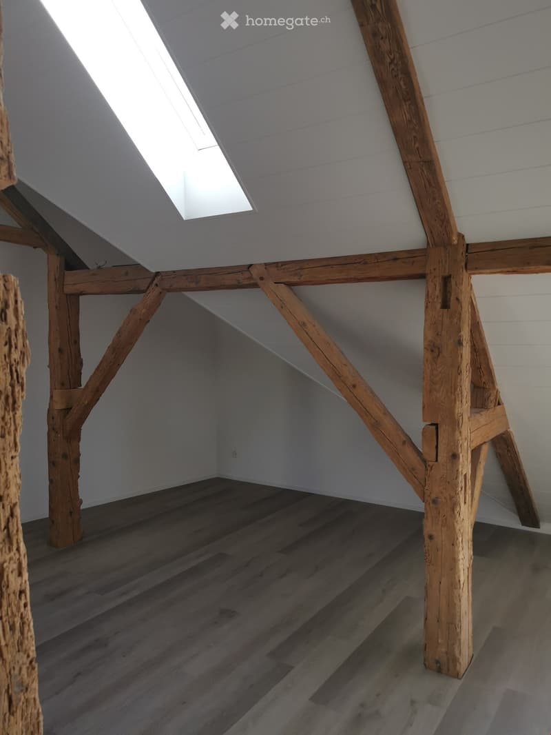 empty room, wooden ceiling beams, white walls, wooden floor