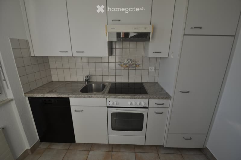Modern kitchen with white cabinets, granite countertop, stainless steel sink, electric stove, oven, and dishwasher.