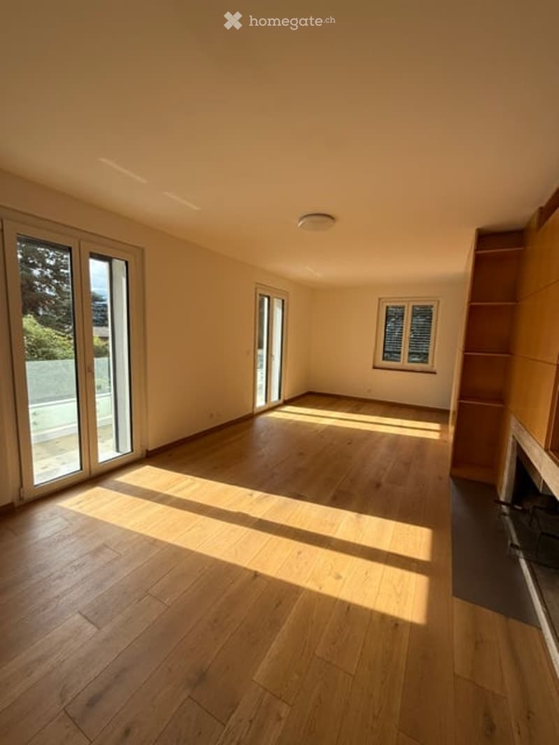 Empty room with wooden flooring, large windows, and natural light. No furniture or equipment present.