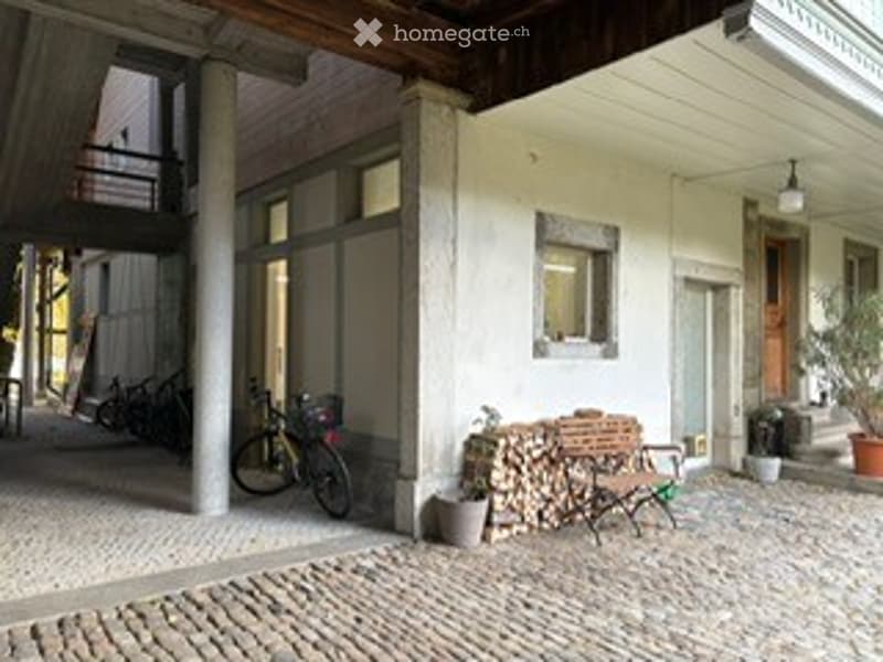 cobblestone street, building with wooden ceiling, bicycle parked, wooden bench, firewood, lamp