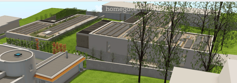 A modern, multi-level building complex with flat roofs, solar panels, and surrounding greenery. The architecture features clean lines and contemporary design elements.
