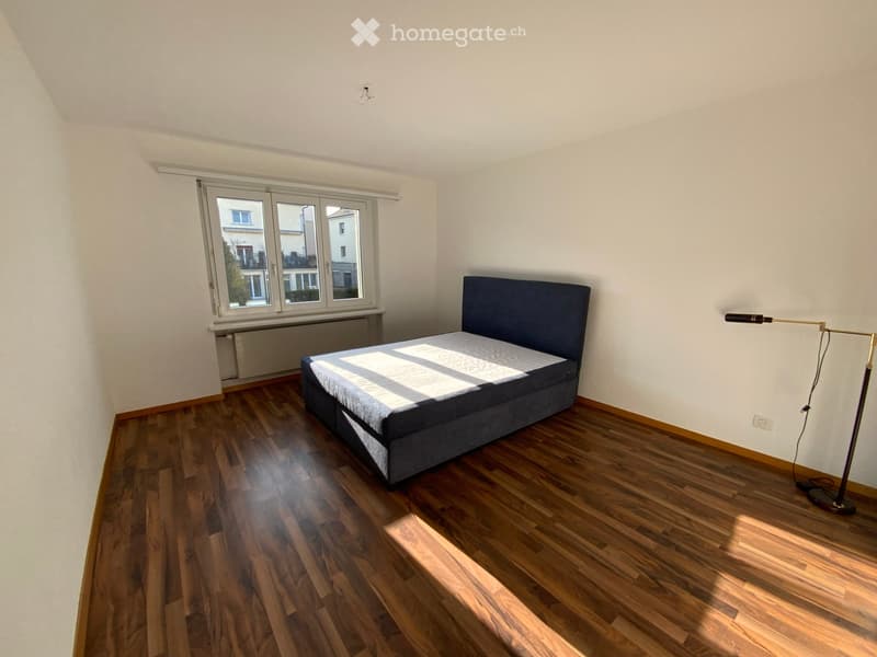 Single bed, wooden floor, window with city view, radiator