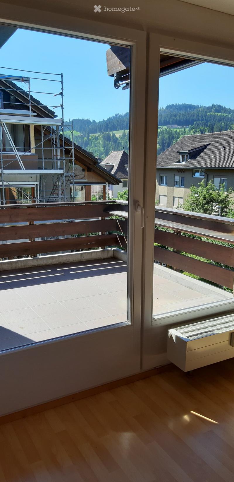 Balcony with wooden railing, tiled floor, and scenic mountain view.