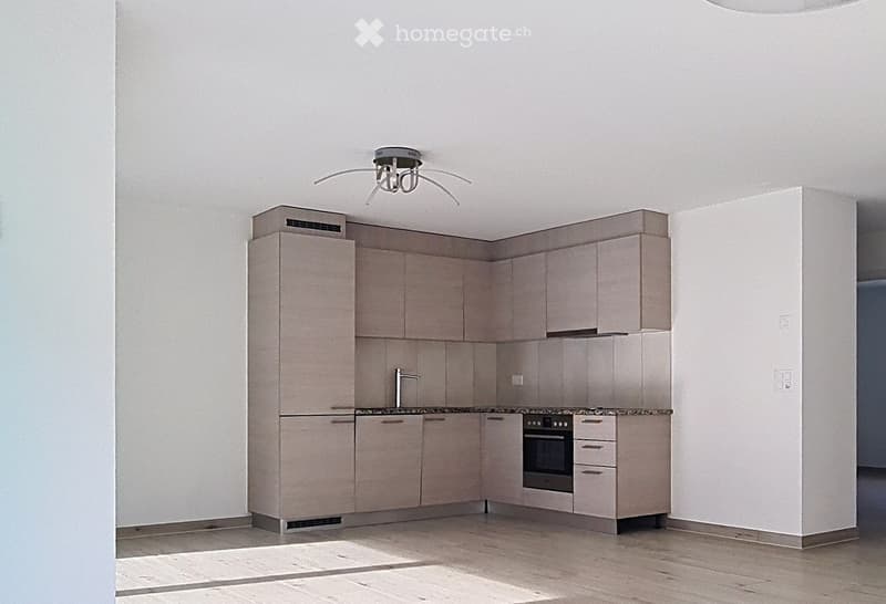 Modern kitchen with light-colored cabinets, a stainless steel oven, a sink with a faucet, and a sleek light fixture on the ceiling.
