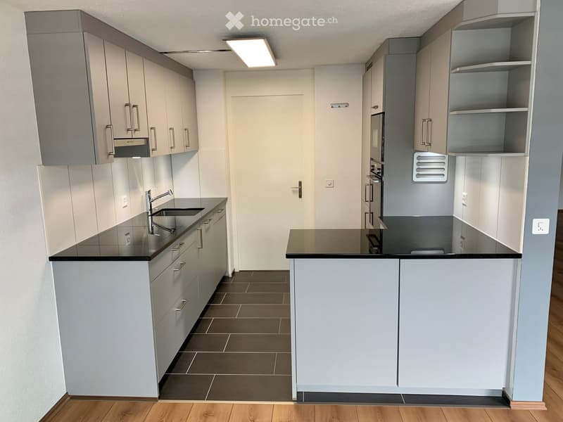 modern kitchen with white cabinets, black countertops, modern appliances