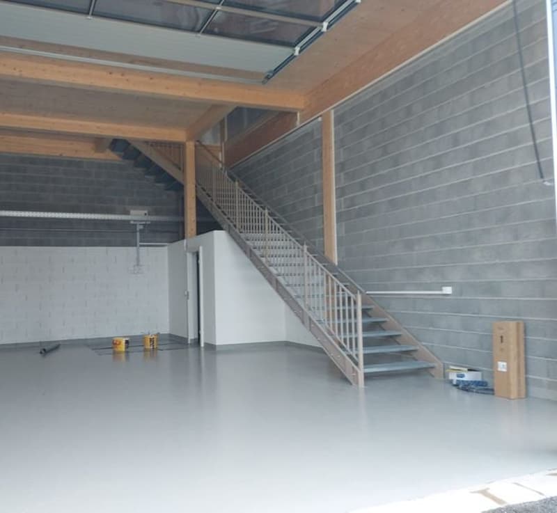 empty room, concrete floor, wooden beams, staircase, gray walls
