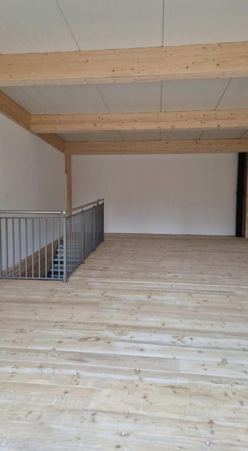 empty room, wooden floor, wooden beams, metal railing