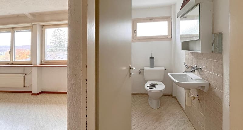 bathroom with toilet and sink, white walls, white tiles, window with outside view