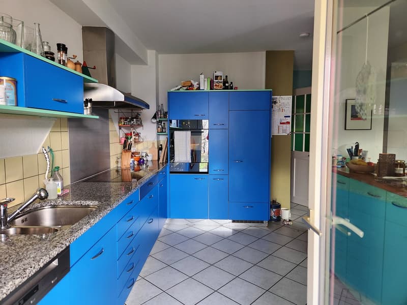 modern kitchen with blue cabinets, granite countertops, stainless steel appliances, tiled floor, sink, dishwasher, washing machine