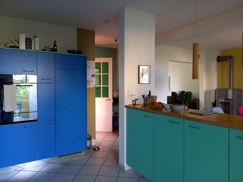 kitchen with blue and green cabinets, wooden countertop, oven, fireplace