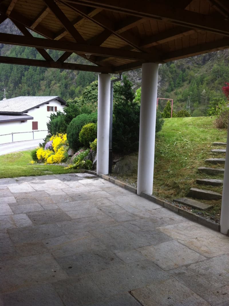 covered patio, stone floor, white pillars, plants, steps, mountain view